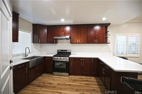 a kitchen with stainless steel appliances granite countertop a sink stove and cabinets