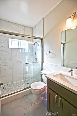 a bathroom with a sink a toilet and shower