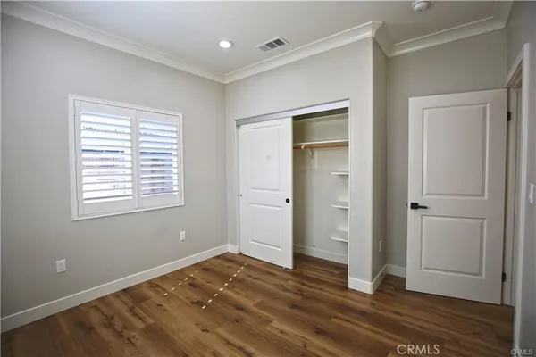 a view of empty room with wooden floor and window