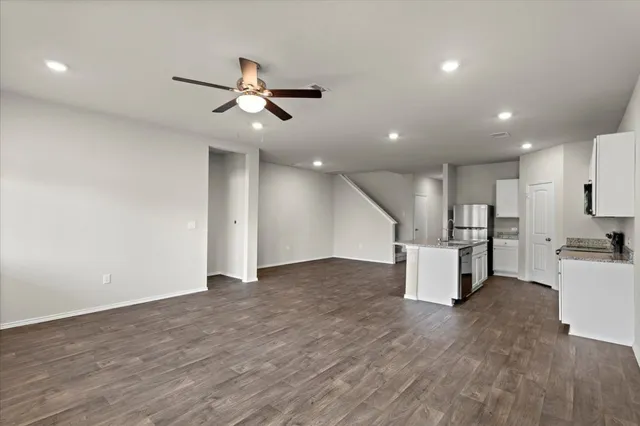 a view of a kitchen with wooden floor and a ceiling fan