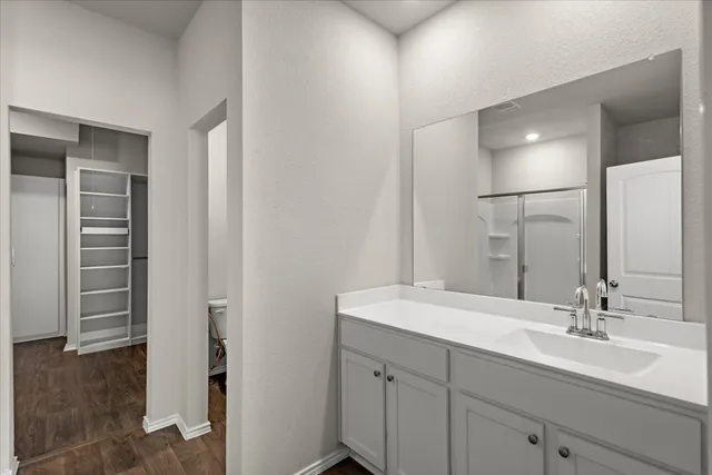 a bathroom with a double vanity sink a mirror and a shower