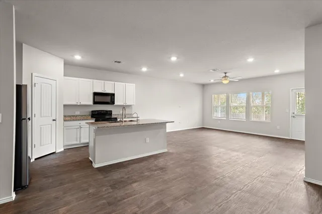 a view of kitchen with microwave oven stove and cabinets