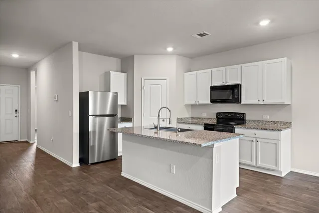a kitchen with stainless steel appliances granite countertop a refrigerator sink and microwave