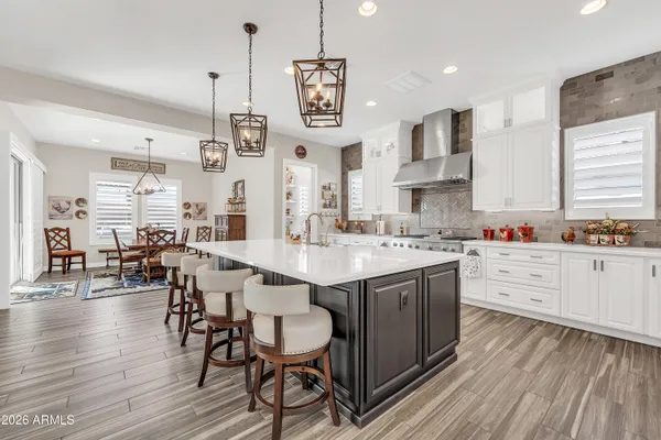 a kitchen with stainless steel appliances kitchen island granite countertop a wooden floor and white cabinets