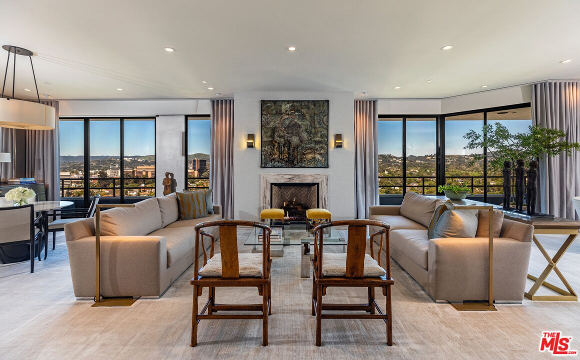 a living room with fireplace furniture and a large window