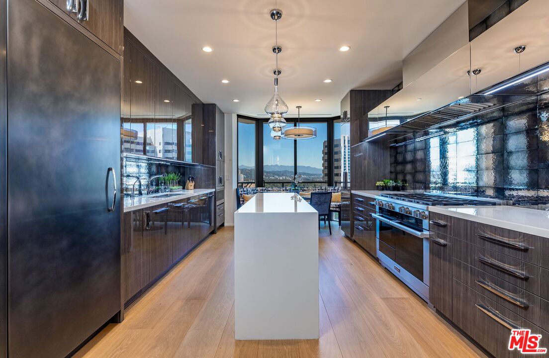 10601 Wilshire Boulevard, Unit 19E Los Angeles, CA 90024 - Photo 14 of 38 a kitchen with stainless steel appliances granite countertop sink stove and wooden floor
