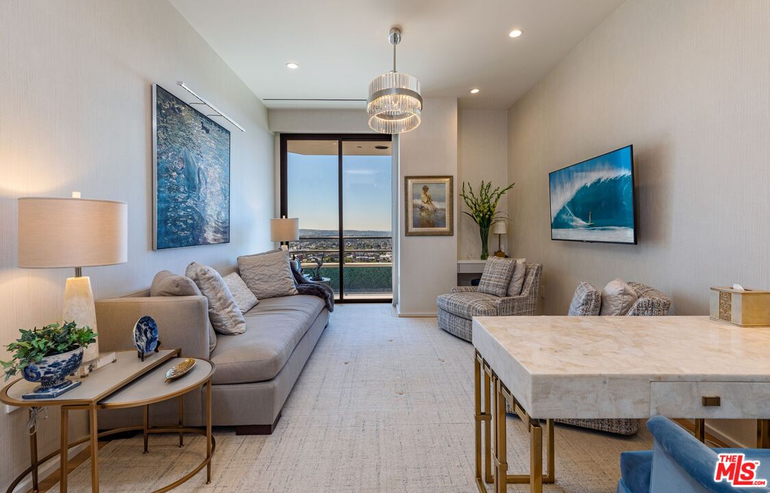 10601 Wilshire Boulevard, Unit 19E Los Angeles, CA 90024 - Photo 33 of 38 a living room with furniture a chandelier and a flat screen tv