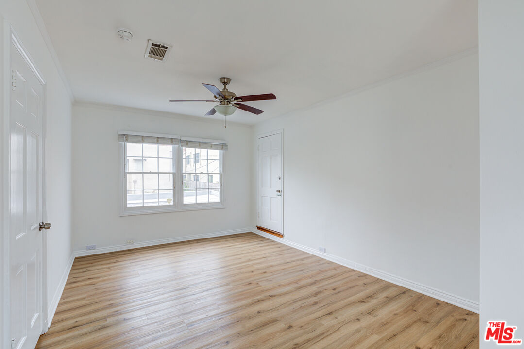 9643 Charleville Boulevard Beverly Hills, CA 90212 - Photo 11 of 21 a view of an empty room with wooden floor and a window
