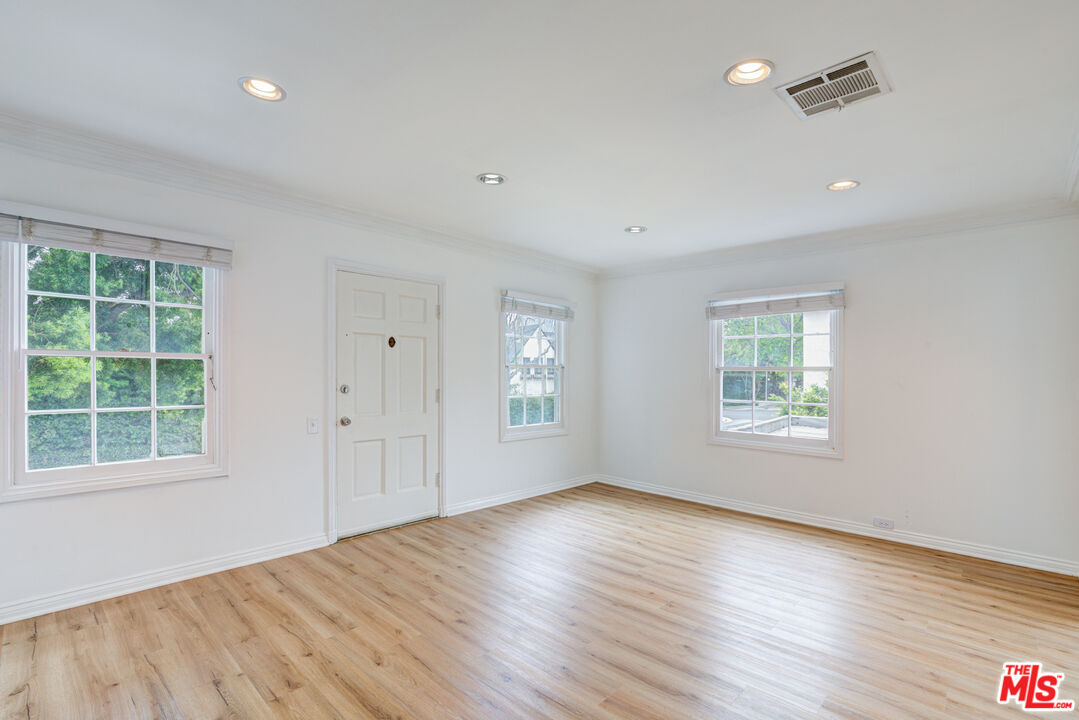 9643 Charleville Boulevard Beverly Hills, CA 90212 - Photo 3 of 21 a view of an empty room with wooden floor and a window