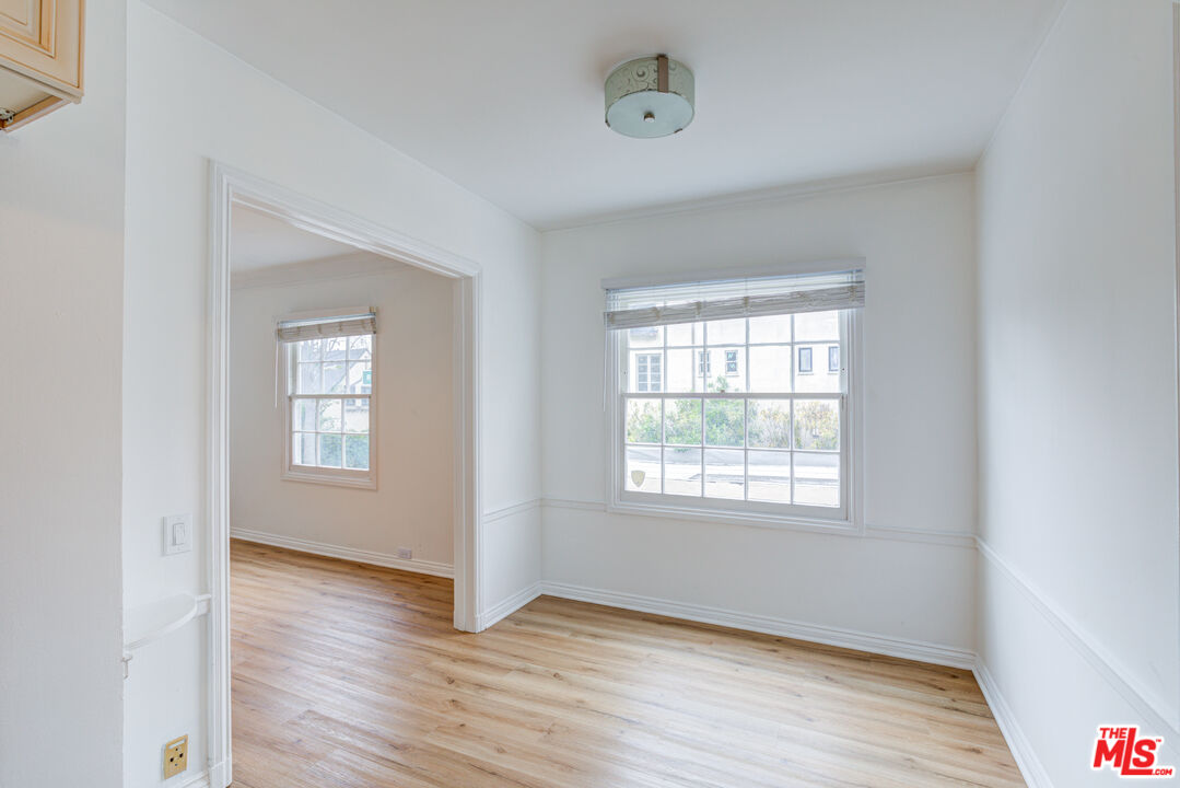 9643 Charleville Boulevard Beverly Hills, CA 90212 - Photo 4 of 21 an empty room with wooden floor and windows