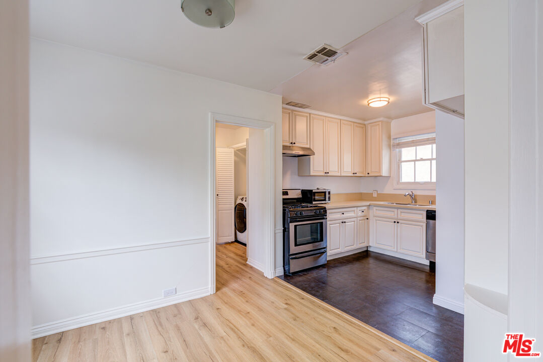 9643 Charleville Boulevard Beverly Hills, CA 90212 - Photo 5 of 21 a kitchen with a refrigerator stove and wooden floor