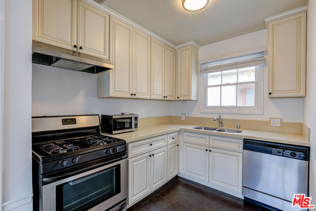 9643 Charleville Boulevard Beverly Hills, CA 90212 - Photo 7 of 21 a kitchen with cabinets appliances a sink and a window