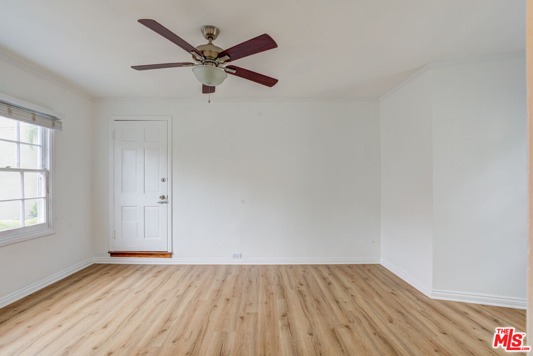 9643 Charleville Boulevard Beverly Hills, CA 90212 - Photo 9 of 21 an empty room with wooden floor a ceiling fan and windows