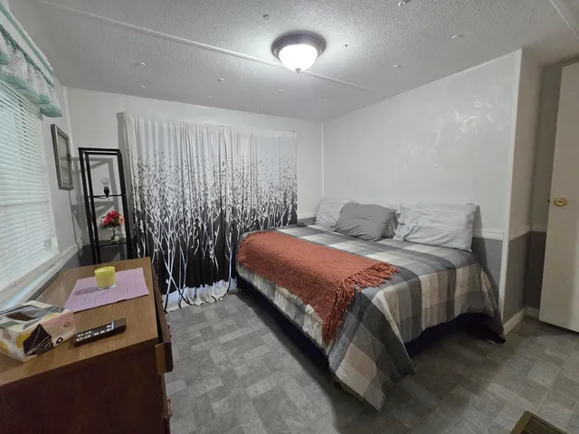 a bedroom with a bed a flat screen tv and a large mirror