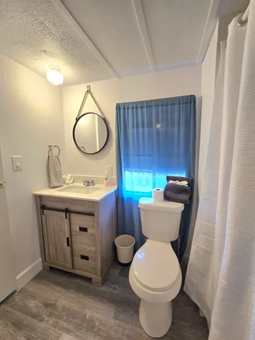 a bathroom with a toilet sink vanity mirror and tub