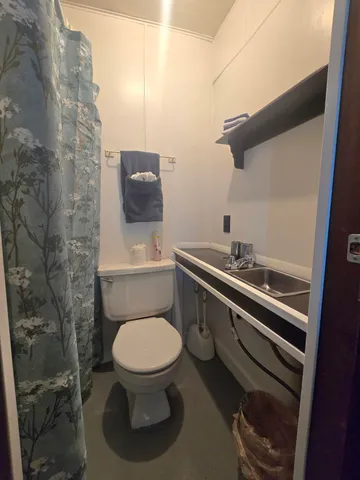 a bathroom with a toilet a sink and mirror