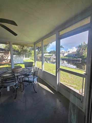 a view of a work space with furniture and floor to ceiling window