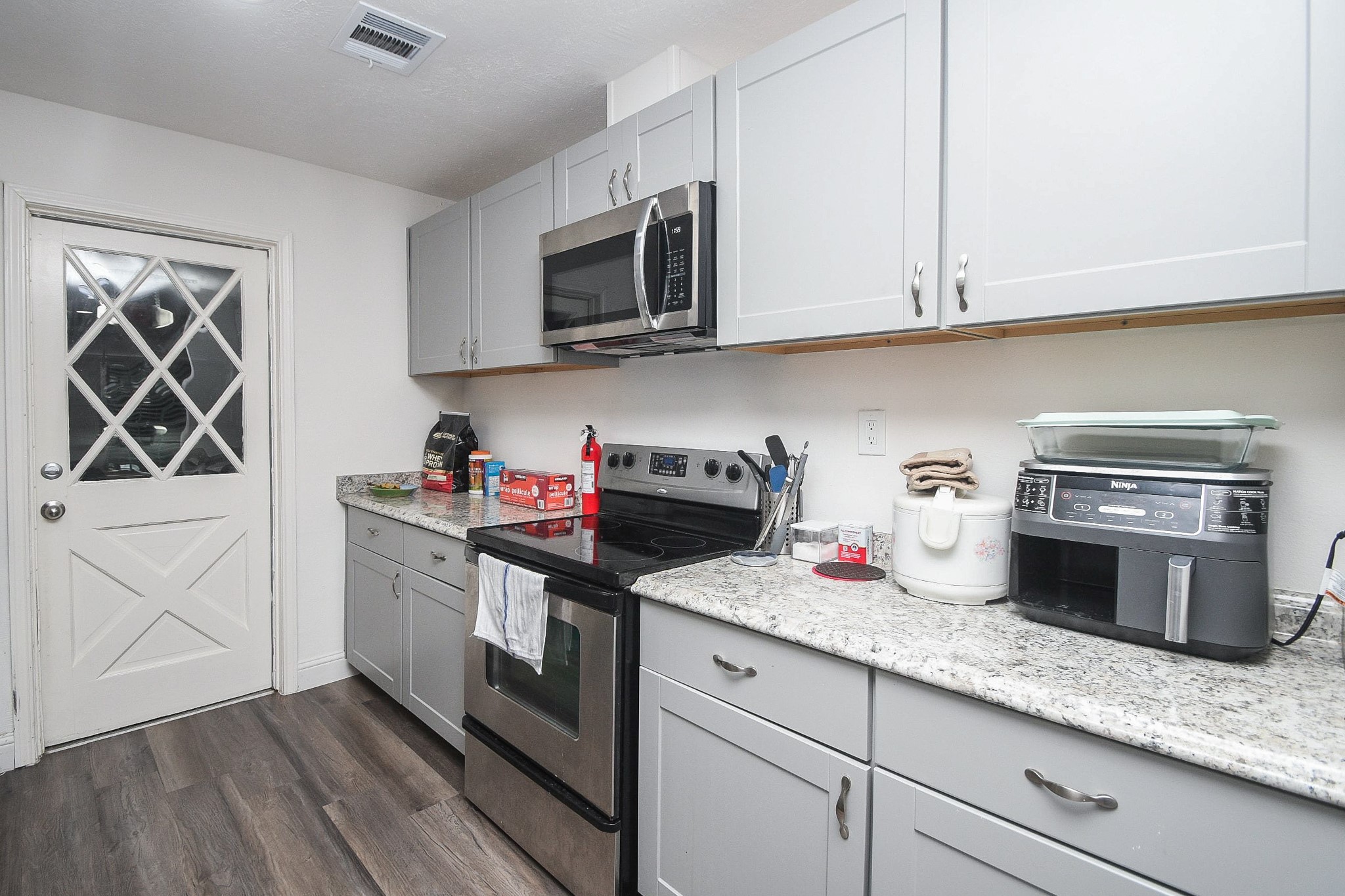 11443 Newbrook Drive Houston, TX 77072 - Photo 11 of 31 a kitchen with granite countertop white cabinets and stainless steel appliances