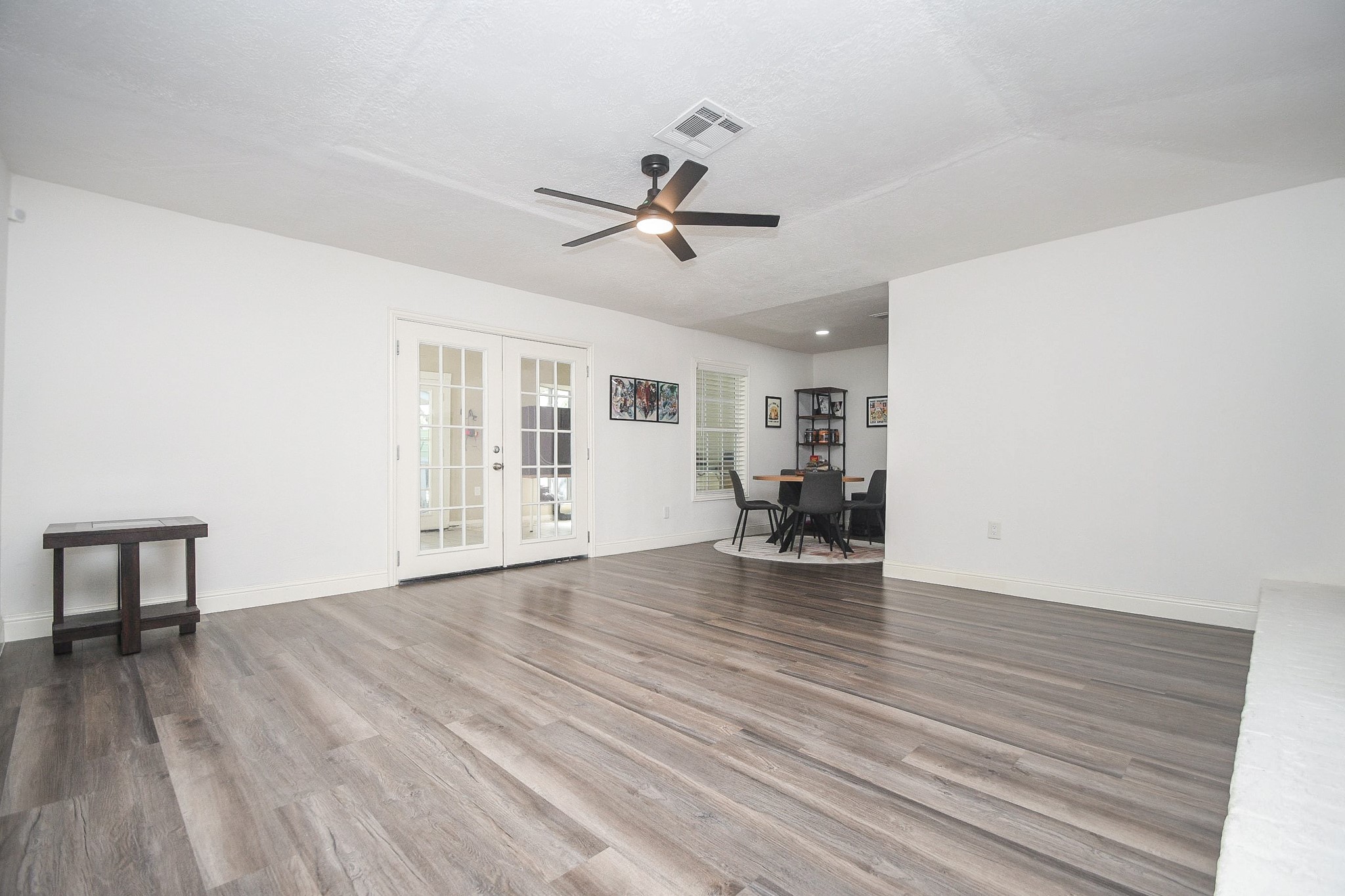 11443 Newbrook Drive Houston, TX 77072 - Photo 7 of 31 a view of an empty room with wooden floor and a ceiling fan