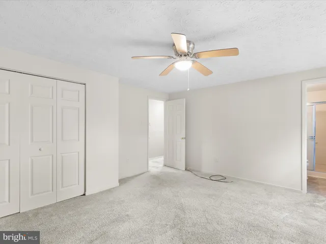 an empty room with closet and windows