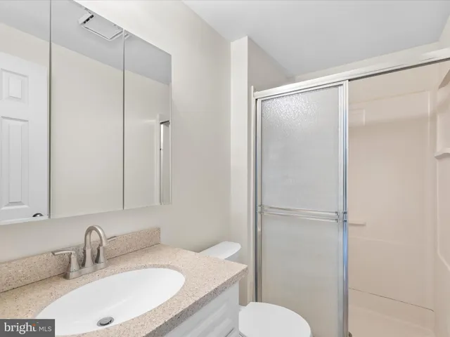 a bathroom with a granite countertop sink toilet and shower