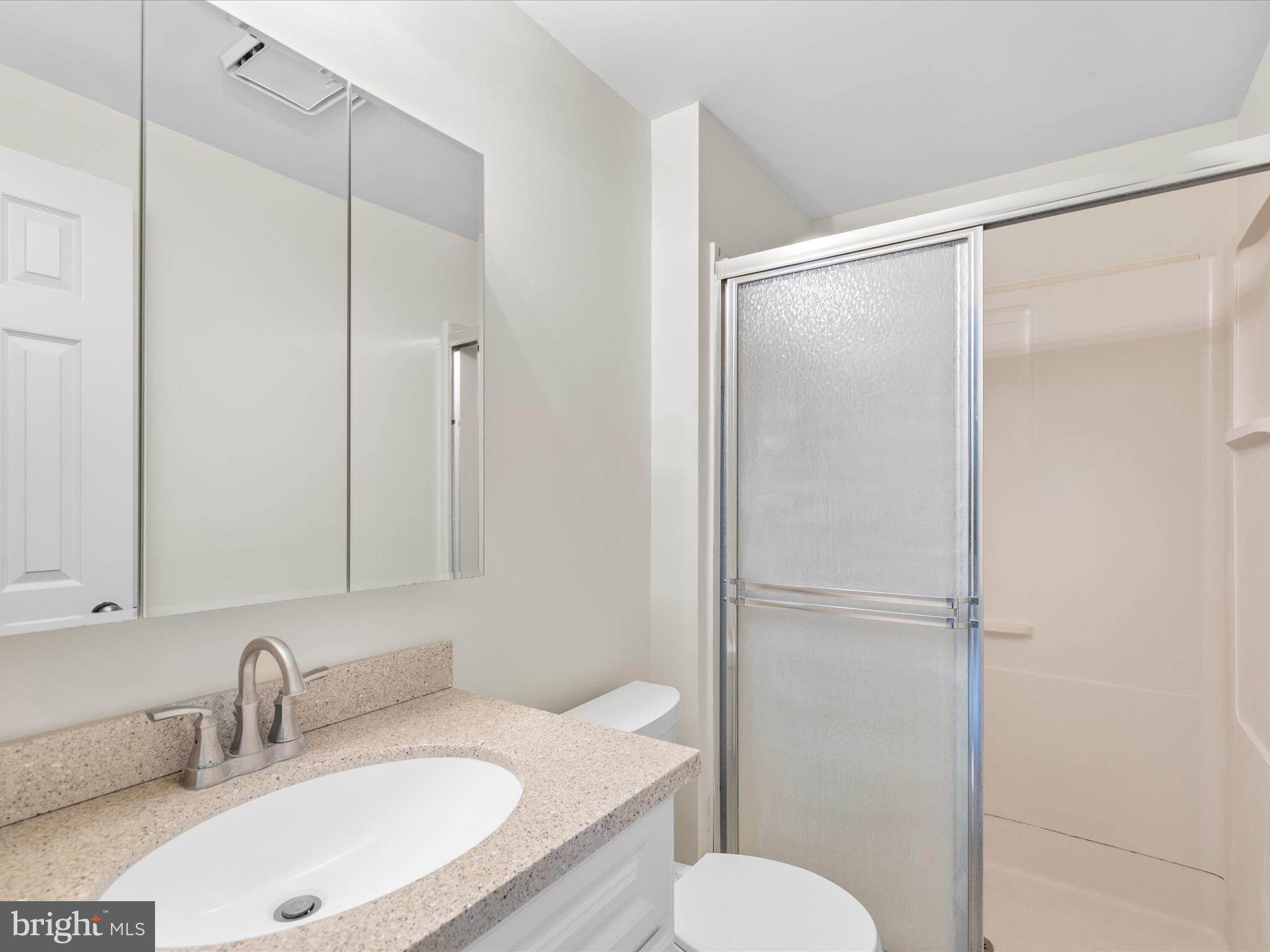 403 West Street Berlin, MD 21811 - Photo 13 of 34 a bathroom with a granite countertop sink toilet and shower