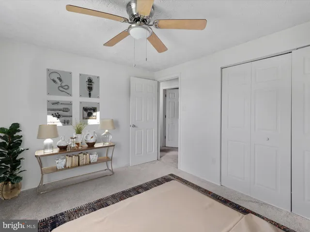 a living room with furniture and a chandelier fan