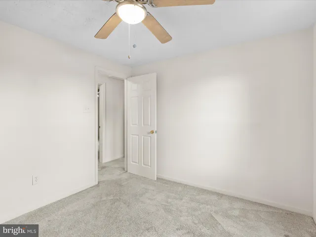 an empty room with chandelier fan