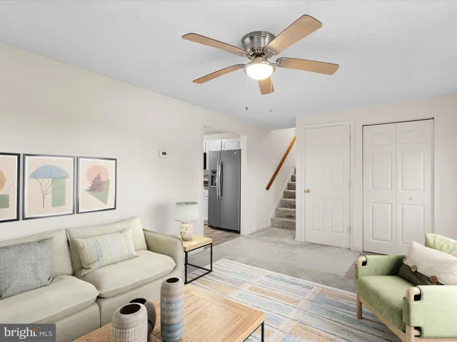 a living room with furniture and a ceiling fan