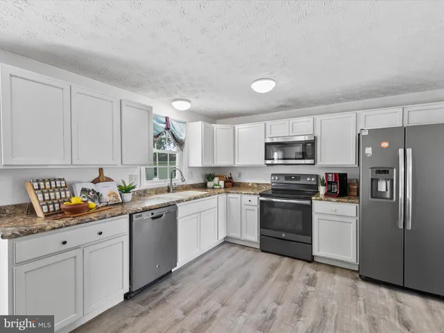a kitchen with granite countertop stainless steel appliances and sink