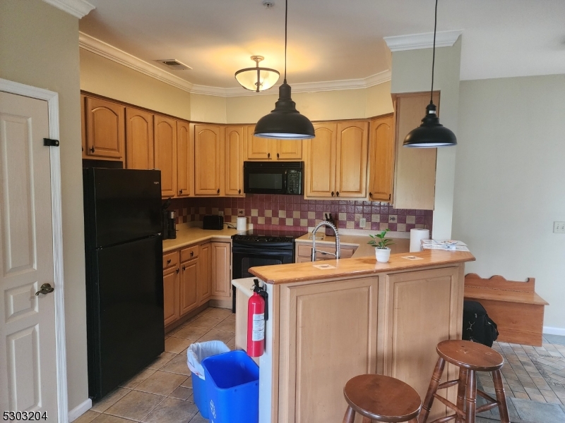 7 Maple Crescent, Unit 11 Vernon, NJ 07462 - Photo 20 of 42 a kitchen with stainless steel appliances granite countertop a refrigerator a sink dishwasher a stove and a dining table with wooden floor