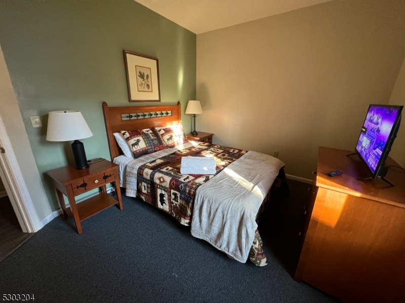 7 Maple Crescent, Unit 11 Vernon, NJ 07462 - Photo 28 of 42 a bedroom with a bed and a lamp with the dresser