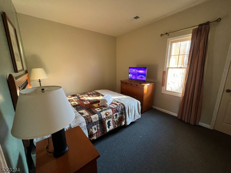 7 Maple Crescent, Unit 11 Vernon, NJ 07462 - Photo 30 of 42 a bedroom with a bed dresser and window