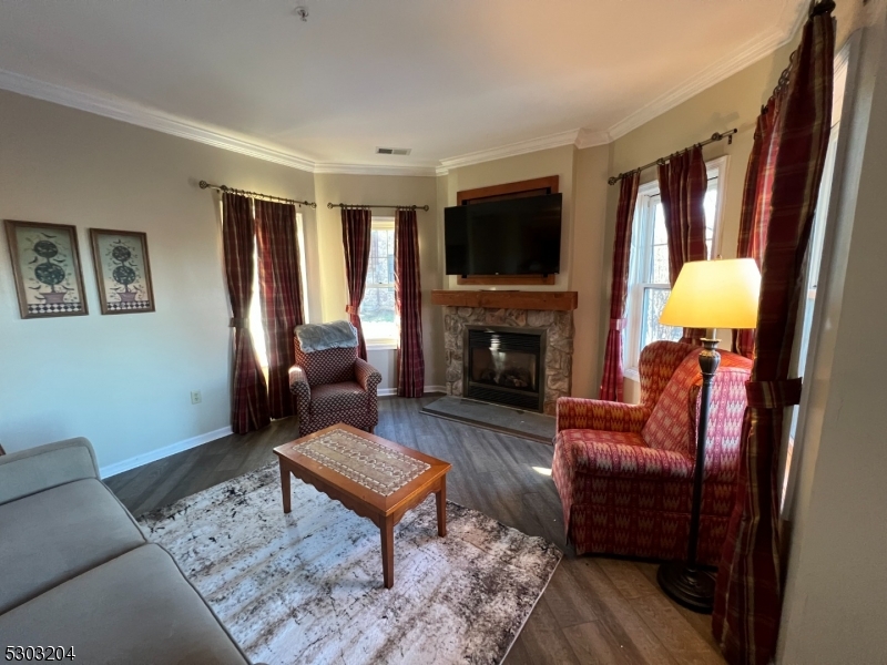 7 Maple Crescent, Unit 11 Vernon, NJ 07462 - Photo 5 of 42 a living room with furniture a flat screen tv and a fireplace