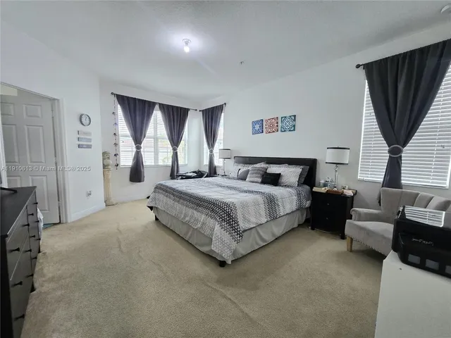 a bedroom with a bed and a large window