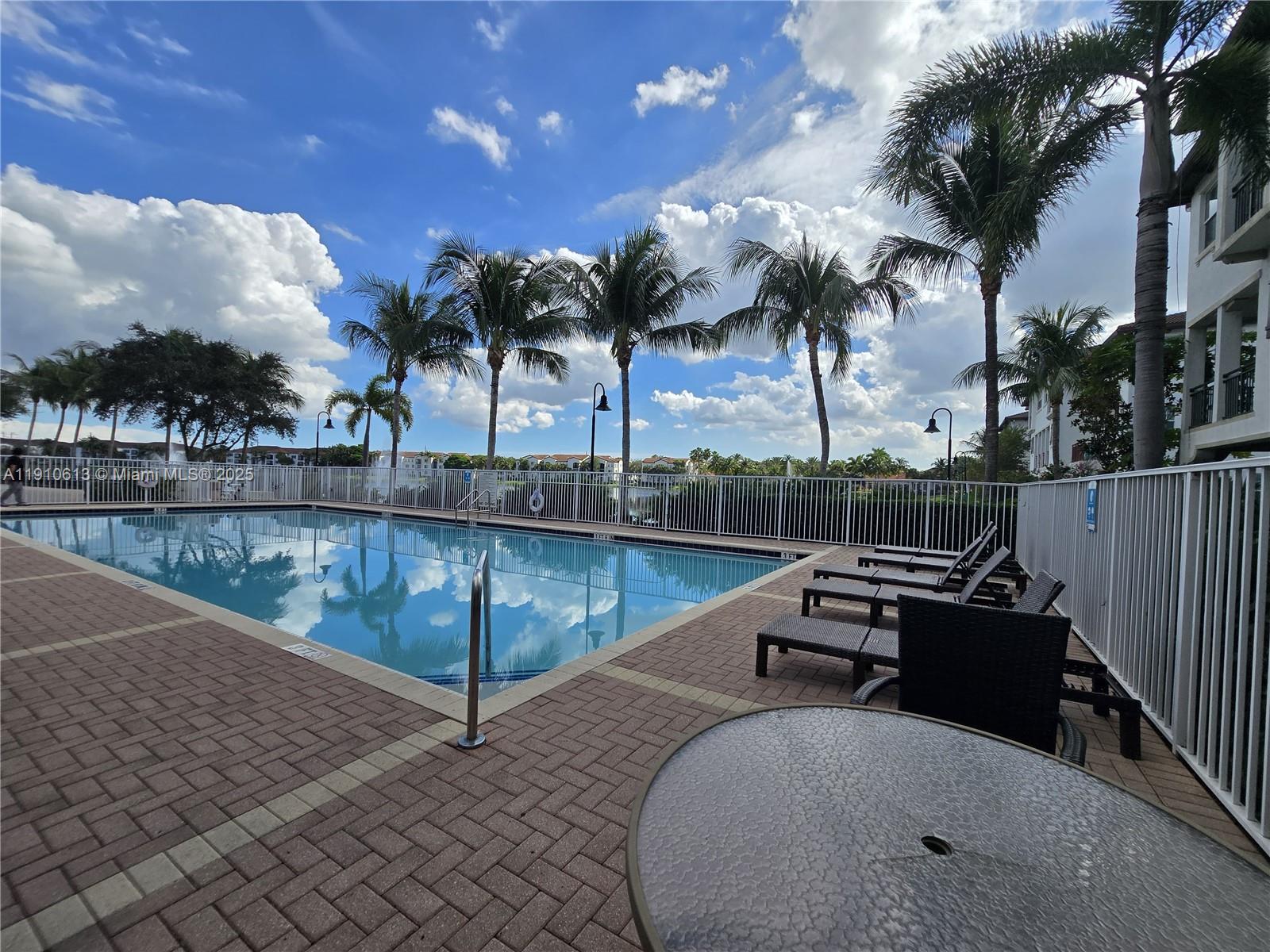 11938 Southwest 26th Court Miramar, FL 33025 - Photo 52 of 62 a view of a swimming pool with a lounge chairs