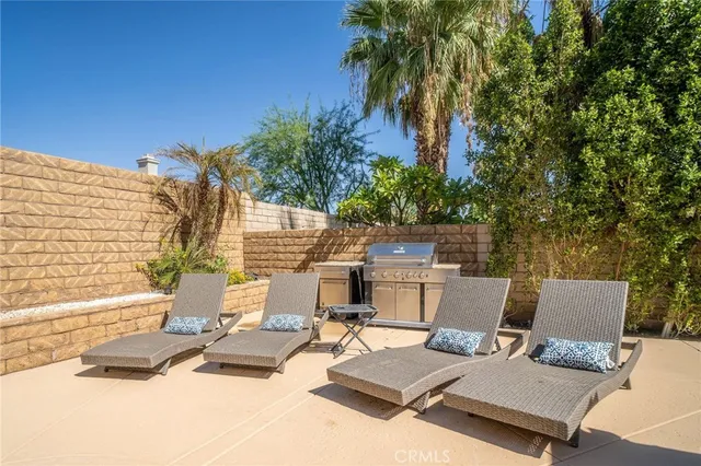 a view of a patio with a table and chairs and potted plants