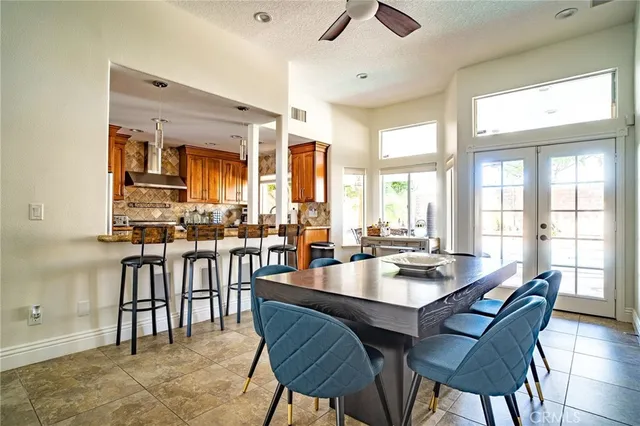a dining room with stainless steel appliances granite countertop a table and chairs