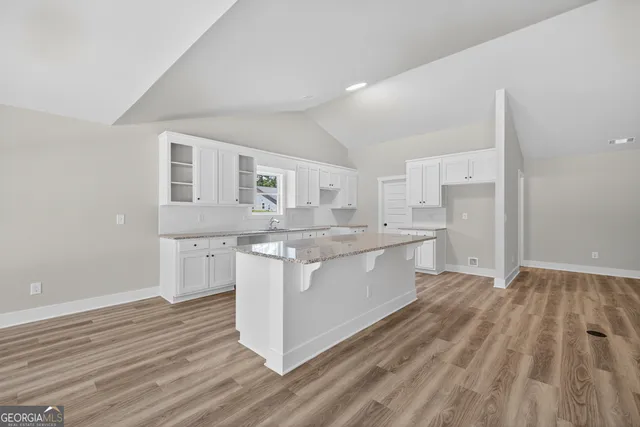 a kitchen with stainless steel appliances granite countertop a white cabinets and wooden floor