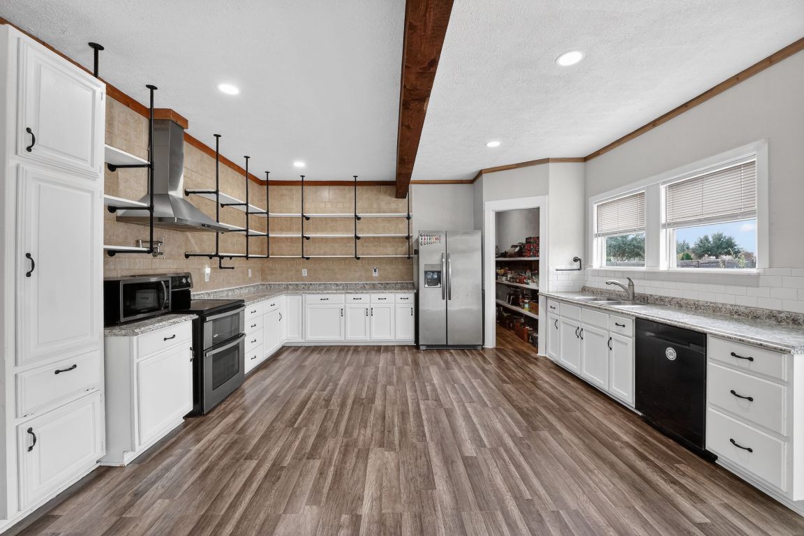 174 Monroe Lane Elgin, TX 78621 - Photo 9 of 21 a kitchen with stainless steel appliances kitchen island granite countertop a stove and a sink