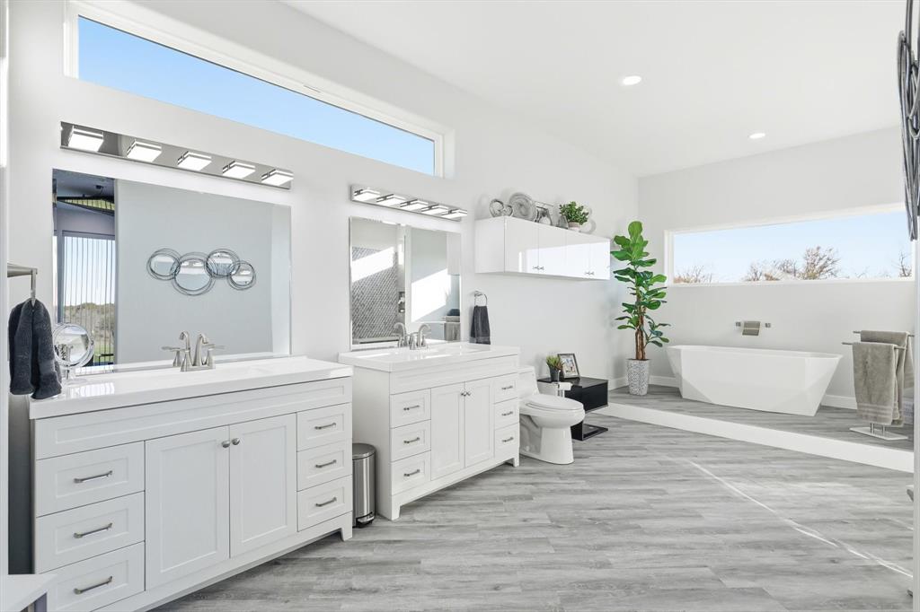 145 ROCK Court Decatur, TX 76234 - Photo 13 of 40 a spacious bathroom with double vanity a mirror a bathtub and shower