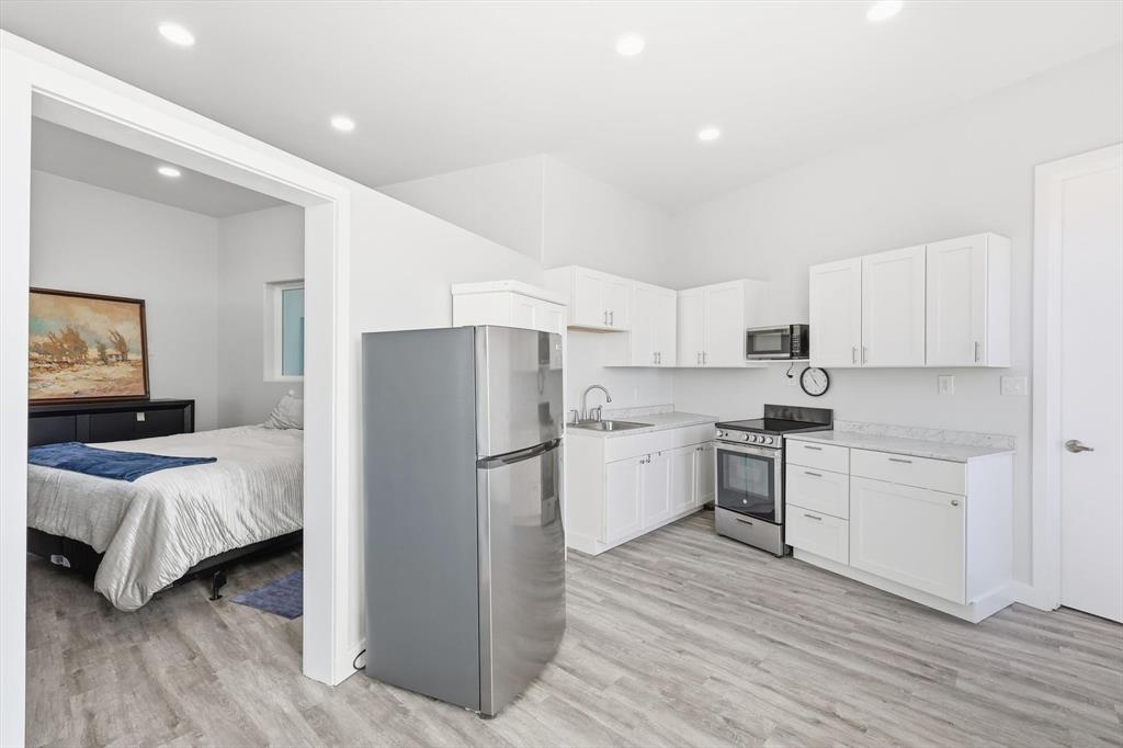 145 ROCK Court Decatur, TX 76234 - Photo 23 of 40 a kitchen with white cabinets and stainless steel appliances