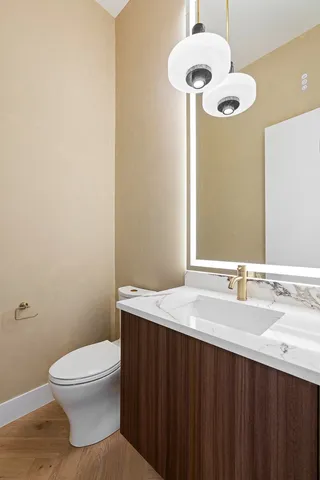 a bathroom with a granite countertop sink a toilet and a mirror