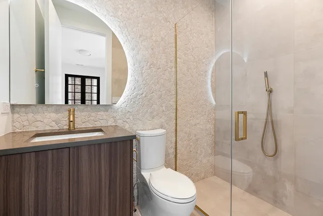 a bathroom with a granite countertop sink mirror and toilet