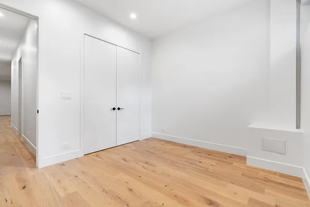 a view of empty room with wooden floor