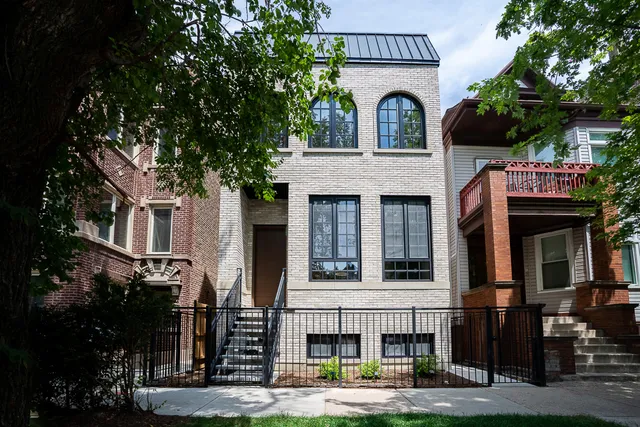 a front view of a house with large trees