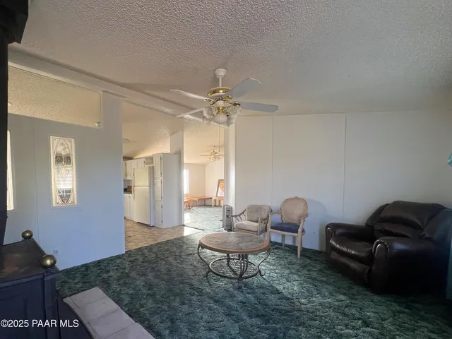 a living room with furniture a chandelier and a rug