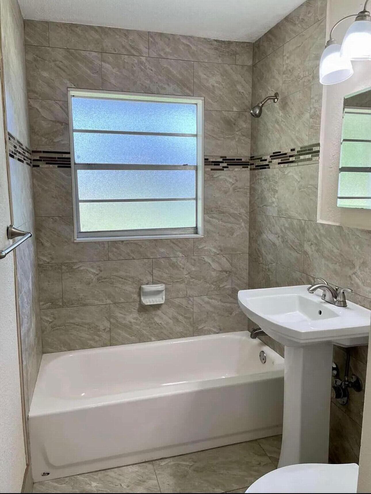 1604 Southeast Apache Avenue Stuart, FL 34994 - Photo 11 of 12 a bathroom with a sink and a bathtub