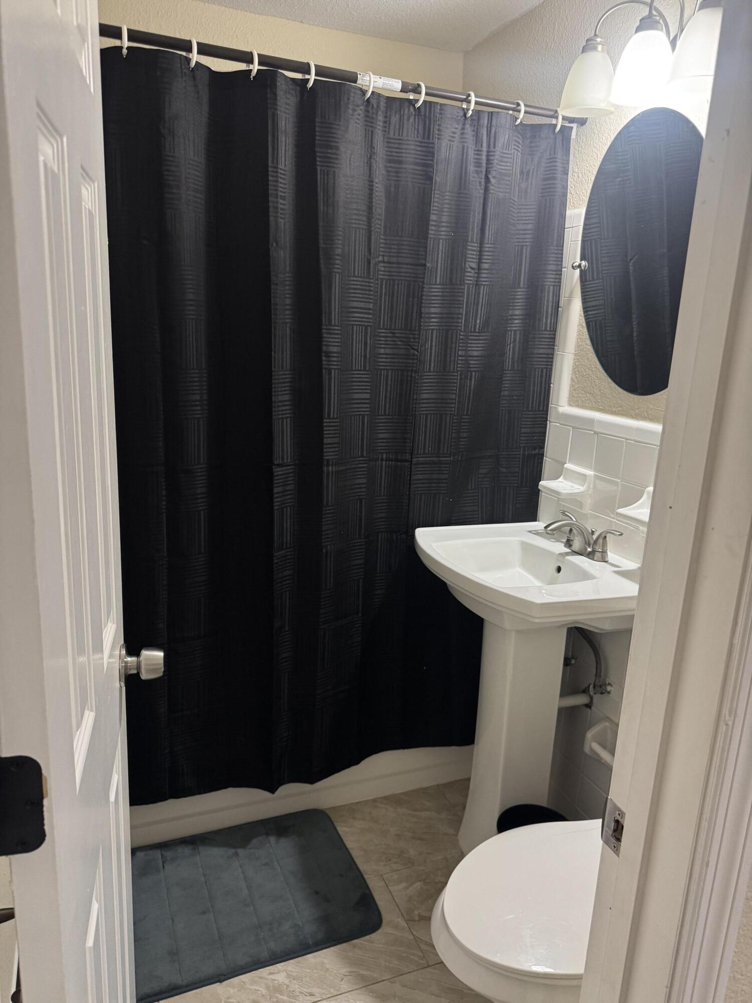1604 Southeast Apache Avenue Stuart, FL 34994 - Photo 8 of 12 a bathroom with a sink a mirror and a toilet
