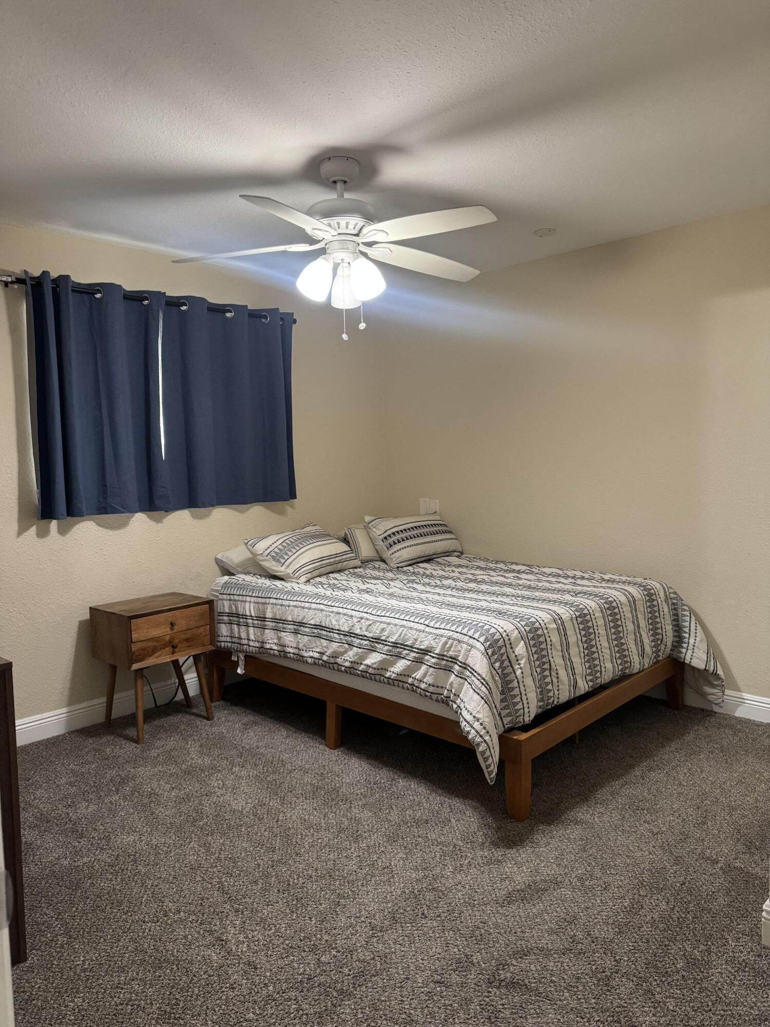 1604 Southeast Apache Avenue Stuart, FL 34994 - Photo 10 of 12 a bedroom with a bed and a chandelier